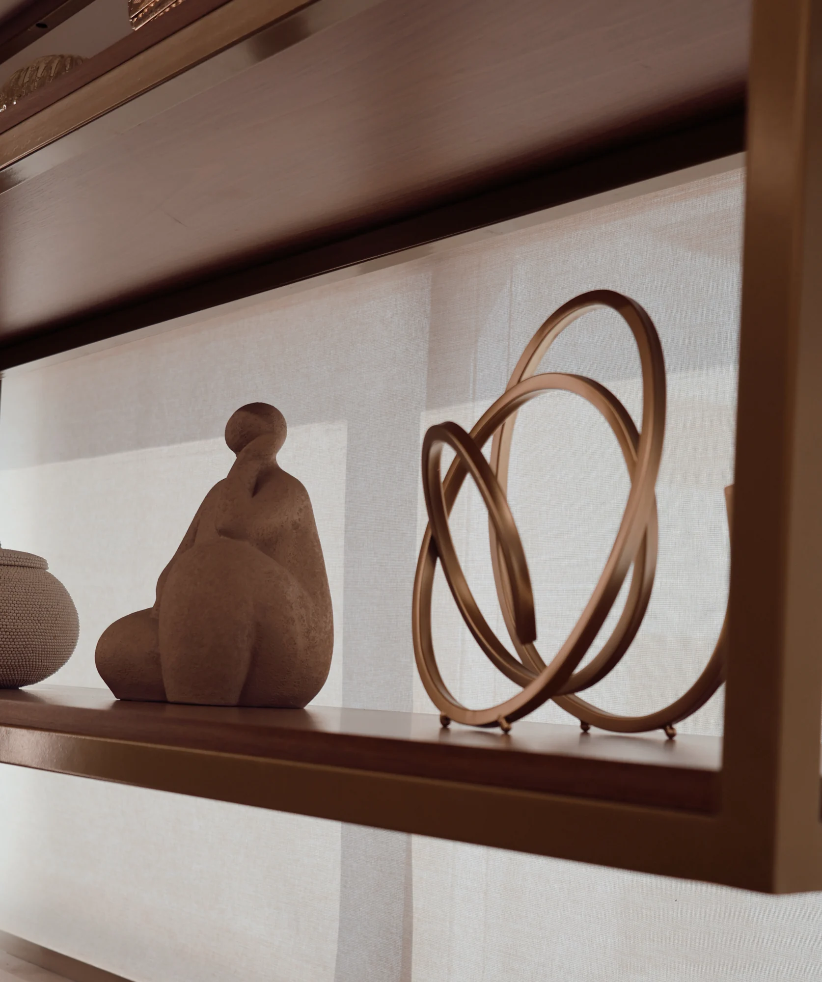 Itens de decoração em uma prateleira da clínica, com escultura e formas circulares